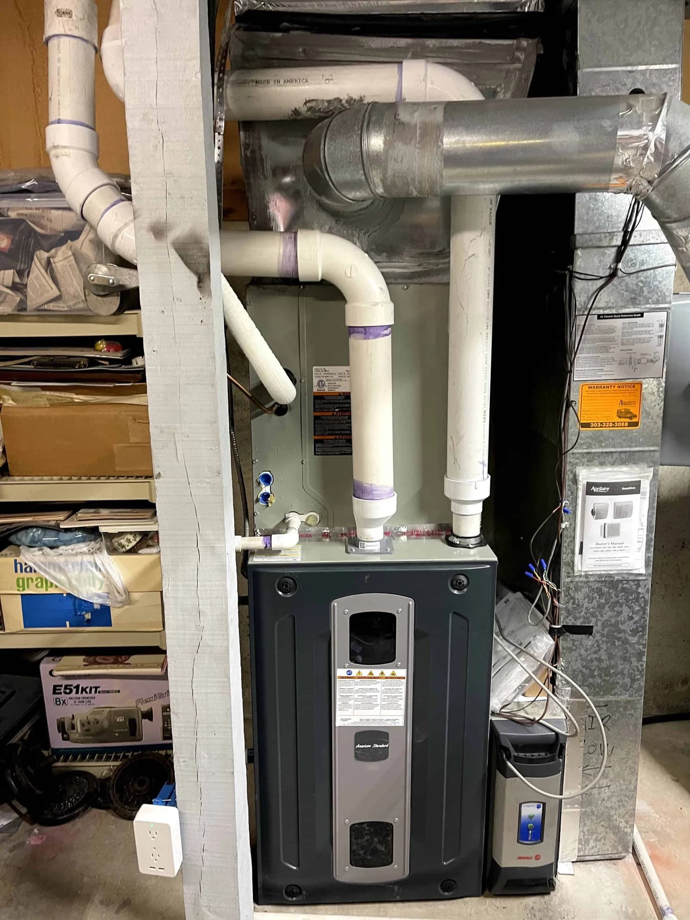 Indoor furnace installed in a utility area with ductwork above
